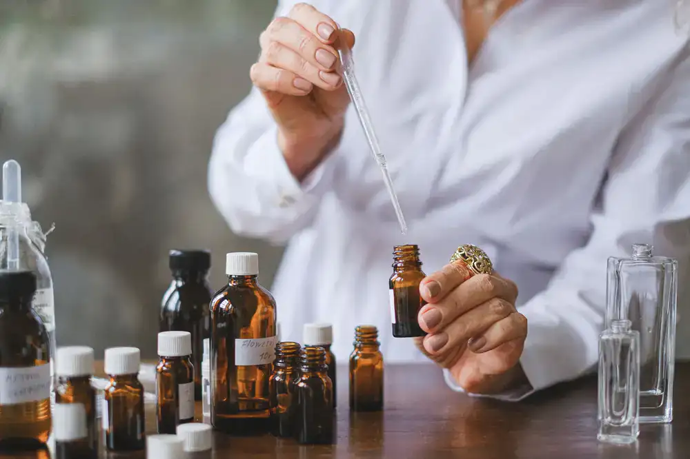 Master perfumer selecting botanical essences for a custom blend