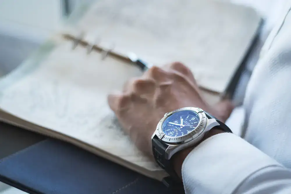 Close-up of a perfumer recording a custom formula in a leather-bound notebook